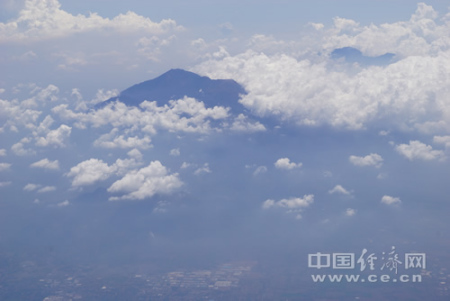 自2015年印尼對(duì)中國(guó)游客實(shí)施免簽征政策以來(lái)，除巴厘島、日惹等傳統(tǒng)旅游熱點(diǎn)，印尼政府積極向中國(guó)游客和投資者推介新的旅游目的地。圖為印尼中爪哇省旅游名城瑪瑯市郊的活火山——阿朱納火山，山腳下就是星羅棋布的村落，中方公司目前正協(xié)助當(dāng)?shù)亻_發(fā)火山相關(guān)旅游項(xiàng)目。中國(guó)經(jīng)濟(jì)網(wǎng)記者田原 攝