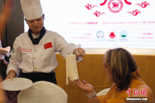 當?shù)貢r間2月15日新春除夕夜，一餐“行走的年夜飯”拉開了巴拿馬華人社區(qū)慶祝中巴建交后首個農(nóng)歷新年一系列活動的大幕。圖為廚藝大師請巴拿馬嘉賓近距離欣賞現(xiàn)場制作的細如發(fā)絲的龍須拉面。2018年“歡樂春節(jié)·行走的年夜飯”活動由北京百年老字號“全聚德”和“東來順”組建廚藝大師團隊，為巴拿馬當?shù)赜押萌耸亢吐冒蛢S胞展現(xiàn)中華傳統(tǒng)烹飪技藝精萃，年夜飯菜點則精選中國各大菜系精華。<a target='_blank' >中新社</a>記者 余瑞冬 攝