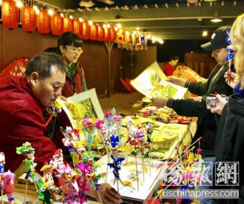 游客對中國傳統(tǒng)藝術刺繡和泥塑人偶充滿興趣。(美國《僑報》/翁羽 攝) 