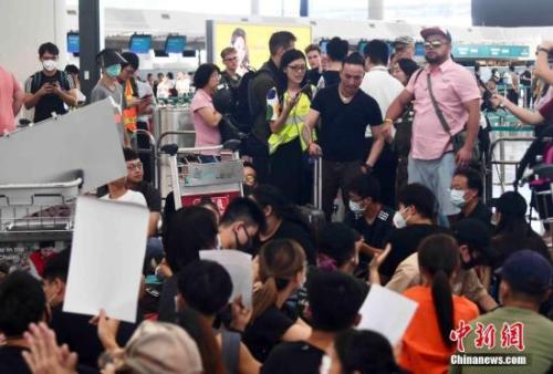 8月13日下午，大批示威者以機場手推車等堵塞香港國際機場1號客運大樓旅客登機行段及保安閘門。 <a target='_blank' >中新社</a>記者 麥尚旻 攝